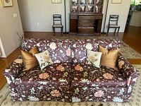 Front view of brown floral sofa with pillows