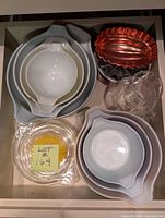 Overhead view showing two nested bowl sets, measuring cup, pie dish, tart pans
