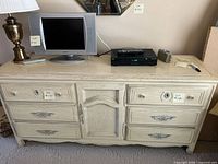 Front view of cream French Provincial dresser showing drawers and center cabinet