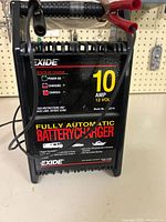 Front view showing Exide branding, 10 AMP 12 V rating, indicator lights and model 7032210
