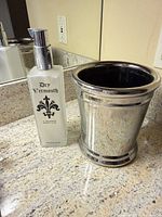 Soap dispenser and metal tumbler side by side on countertop