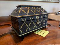 Front angled view of closed box showing gold wheat pattern and latch