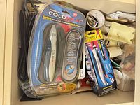 Box containing ColdHeat soldering tool in blister, boxed ColdHeat unit, electrical tape rolls, lamp parts