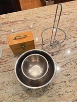All three items together: nested stainless bowls, chrome paper towel holder, wooden box