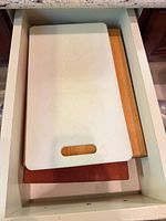 Stacked view showing white plastic board atop wood boards