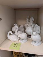 Shelf view showing all porcelain figurines: five birds and horse with rider