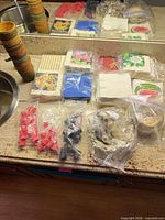 Overview of stacked straw coasters, napkin packs, pourers and bagged accessories on countertop