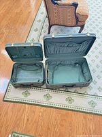 Both suitcases open showing interiors with quilted lining and pockets