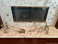 Both polished brass fireplace tool sets in front of fireplace