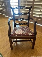 Front view of child’s wood armchair with floral upholstered seat