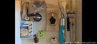 Overall view inside cupboard with boxed Wilton set, pie bird, piping kit, cutters, brushes, thermometer, tamper