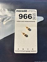 Both gold ball stud earrings on inventory card showing lot number