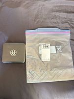 Closed black presentation case next to plastic bag with lot tag
