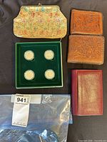 Overview of all coins in display case plus four wallets/purses