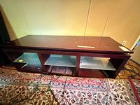 Full view of TV stand front showing compartments and glass shelves