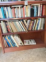 Two shelves filled with assorted hardcover and paperback books on art, architecture and home topics