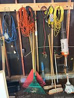 Overall view showing Stihl trimmer/blower, rakes, brooms, extension cords on wall