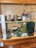 Overall view of both shelves showing glass, crystal, ceramic and metal items