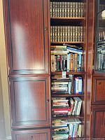 Full view of bookcase section showing leatherbound Harvard Classics on upper shelves and assorted books below