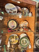 Overview of three shelves showing plates, figurines, vase and small décor