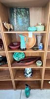 Full shelving view showing painting, pottery, wood bowls and figurines