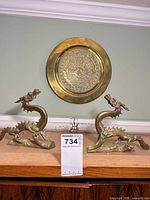 Overall view of two brass dragon bookends and wall plate