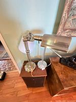 Both brushed nickel adjustable lamps side by side on table showing differing shades