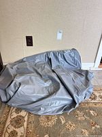Deflated gray air mattress on floor