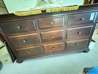Full front view of dark cherry nine-drawer dresser