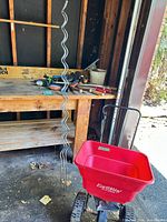 EarthWay spreader, wavy stakes, hand tools on bench