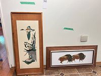 Both framed prints leaning against wall