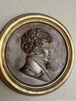 Front view of gilded profile roundel showing overall design and gold finish