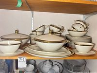Full view of stacked dinnerware showing plates, bowls, cups, covered dishes