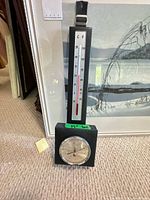 Full view of barometer-thermometer unit in front of framed print