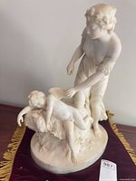 Full view of marble sculpture showing both figures and base