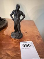 front view of bronze standing male worker figure on base with lot tag visible