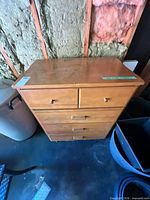 Front view of dresser showing five drawers, light honey finish