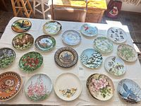 All 20 decorative plates laid out on table