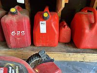 Row of red gas cans, close view of sizes and caps