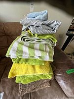 Stack of assorted towels showing colors and textures with bath mat at bottom