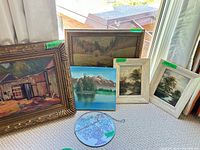Group shot of five framed paintings and one suncatcher