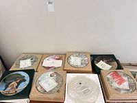 Eight boxed plates and one binder with two plates displayed