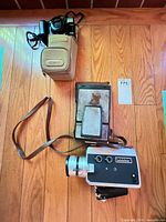 Both cameras, grip, case and strap on floor