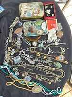 entire lot spread on black fabric showing variety of jewelry and tins