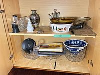 Overview of cabinet shelves with glass, ceramic, metal and plastic items
