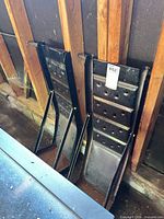 pair of black metal car ramps leaning against wall