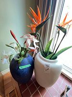 Blue and white planters side by side with artificial flowers inside