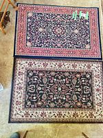 Both oriental rugs laid side by side showing overall design, colors, and relative size.