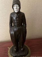 Full view of bronze and ivory hooded woman figure on base