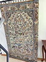 Full view of hanging Persian rug showing overall pattern and colours
